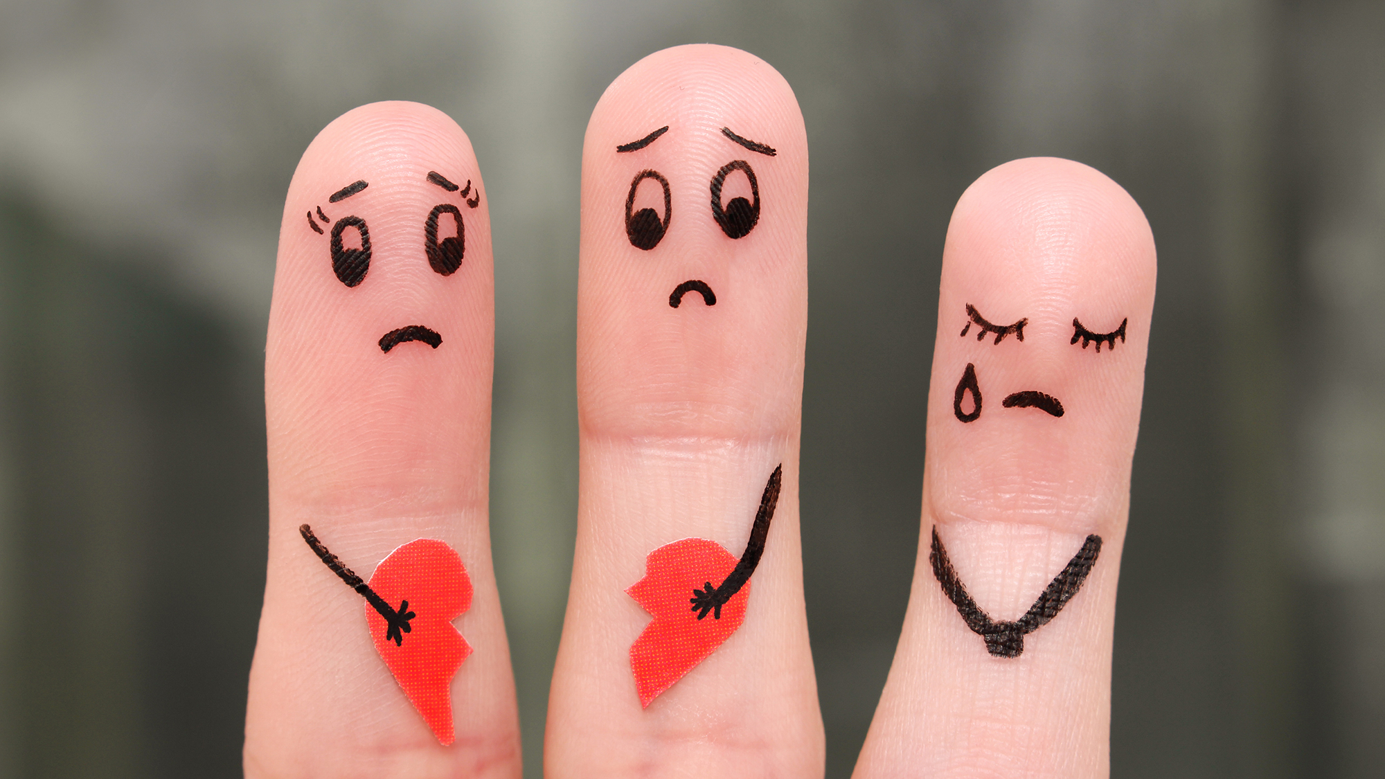 Drei Finger mit aufgemalter trauriger Familie