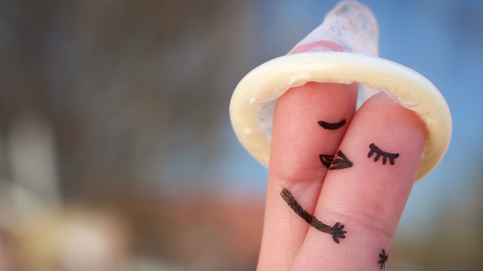 Zwei Finger unter einem Kondomhütchen