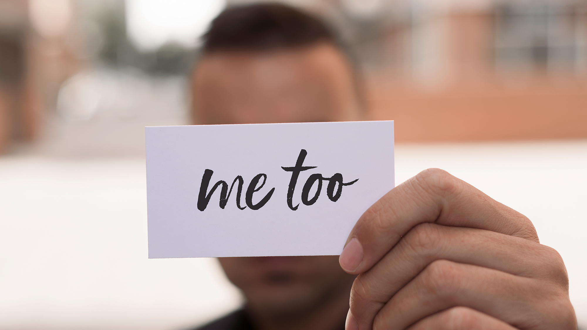 Junge hält Schild hoch mit Aufschrift "Me too"