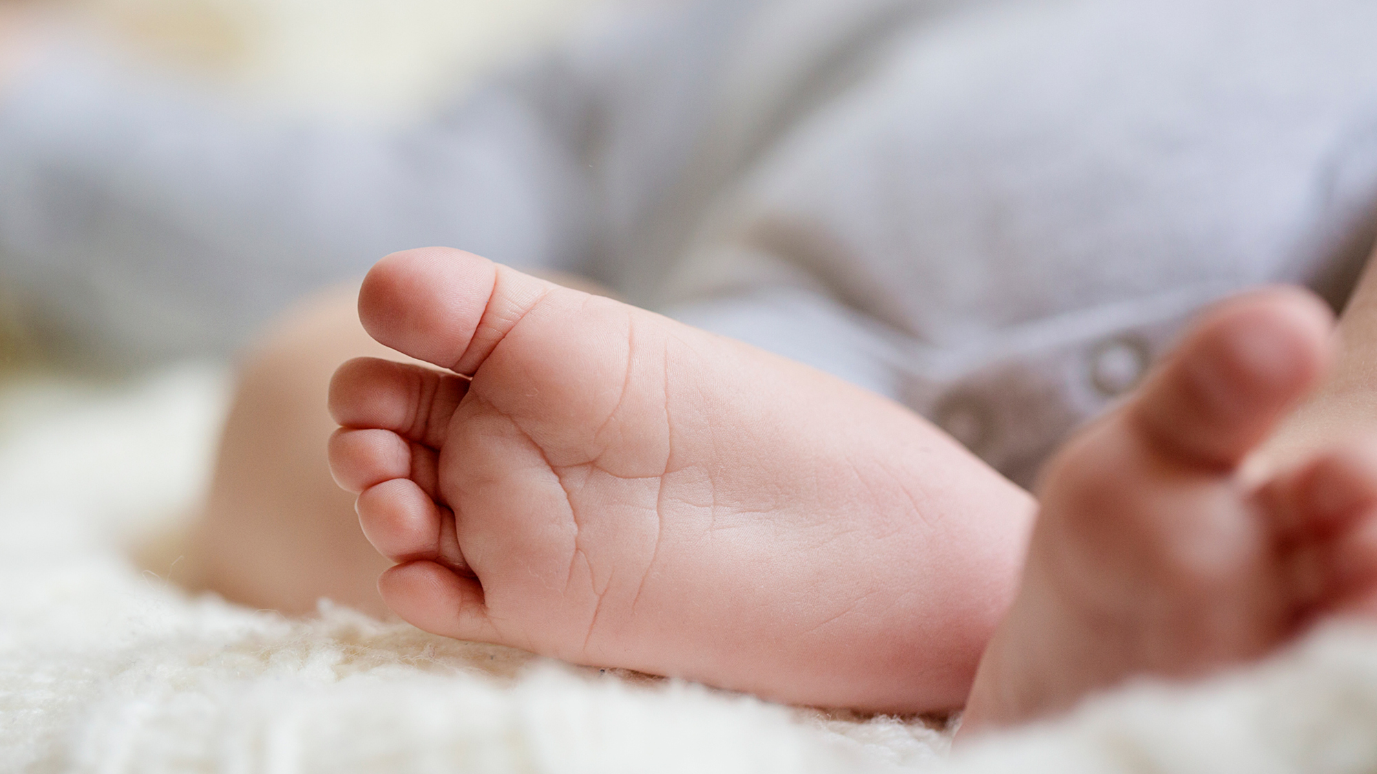 Babyfüße in einer flauschigen Decke eingewickelt.