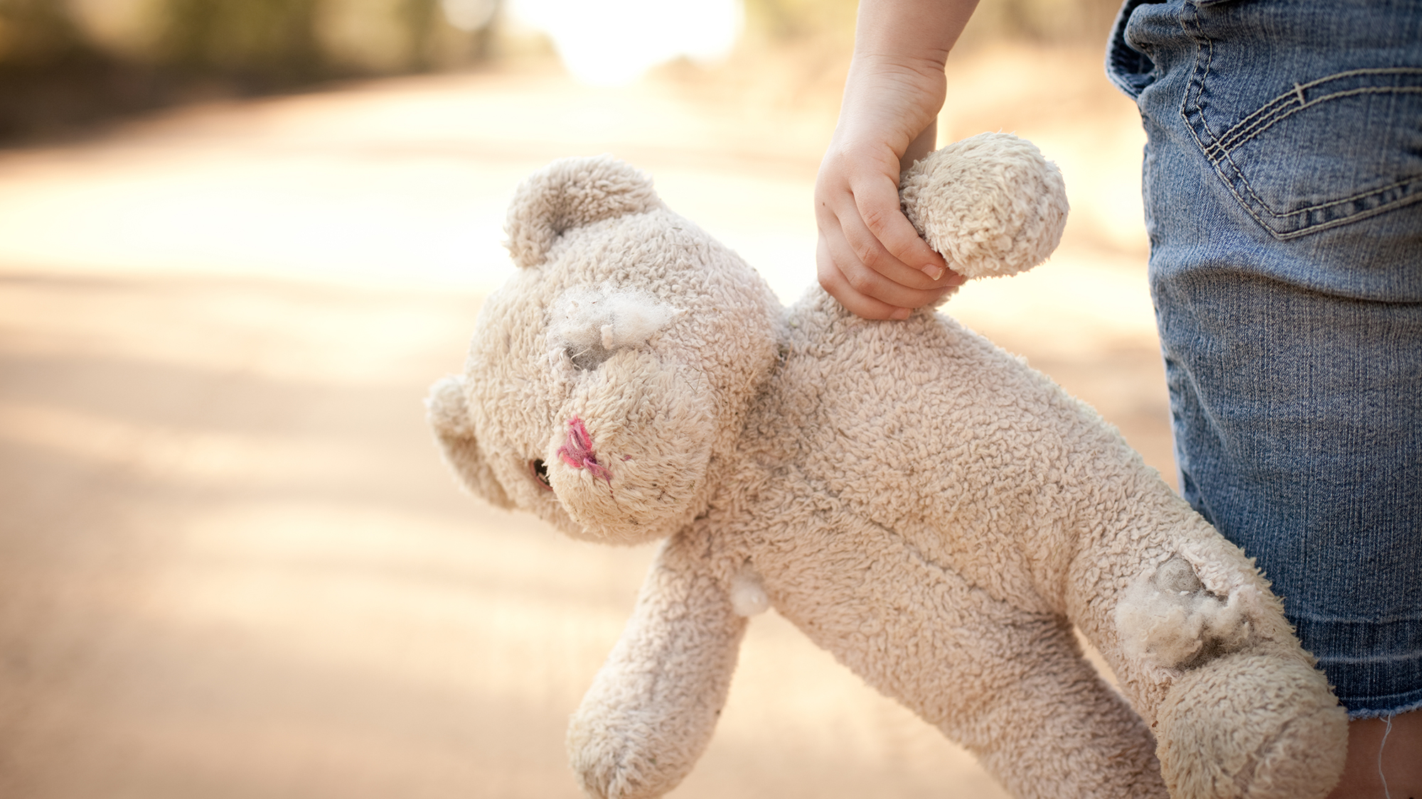 Teddy wird von Kinderhand getragen