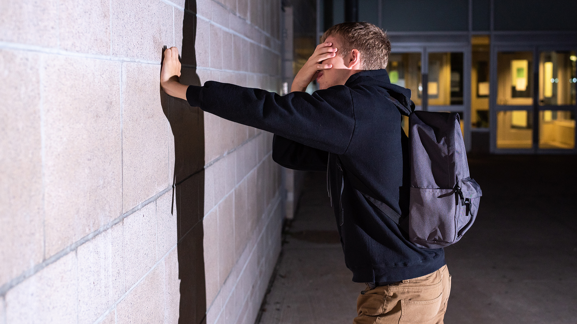 Junge lehnt sich verzweifelt gegen Wand