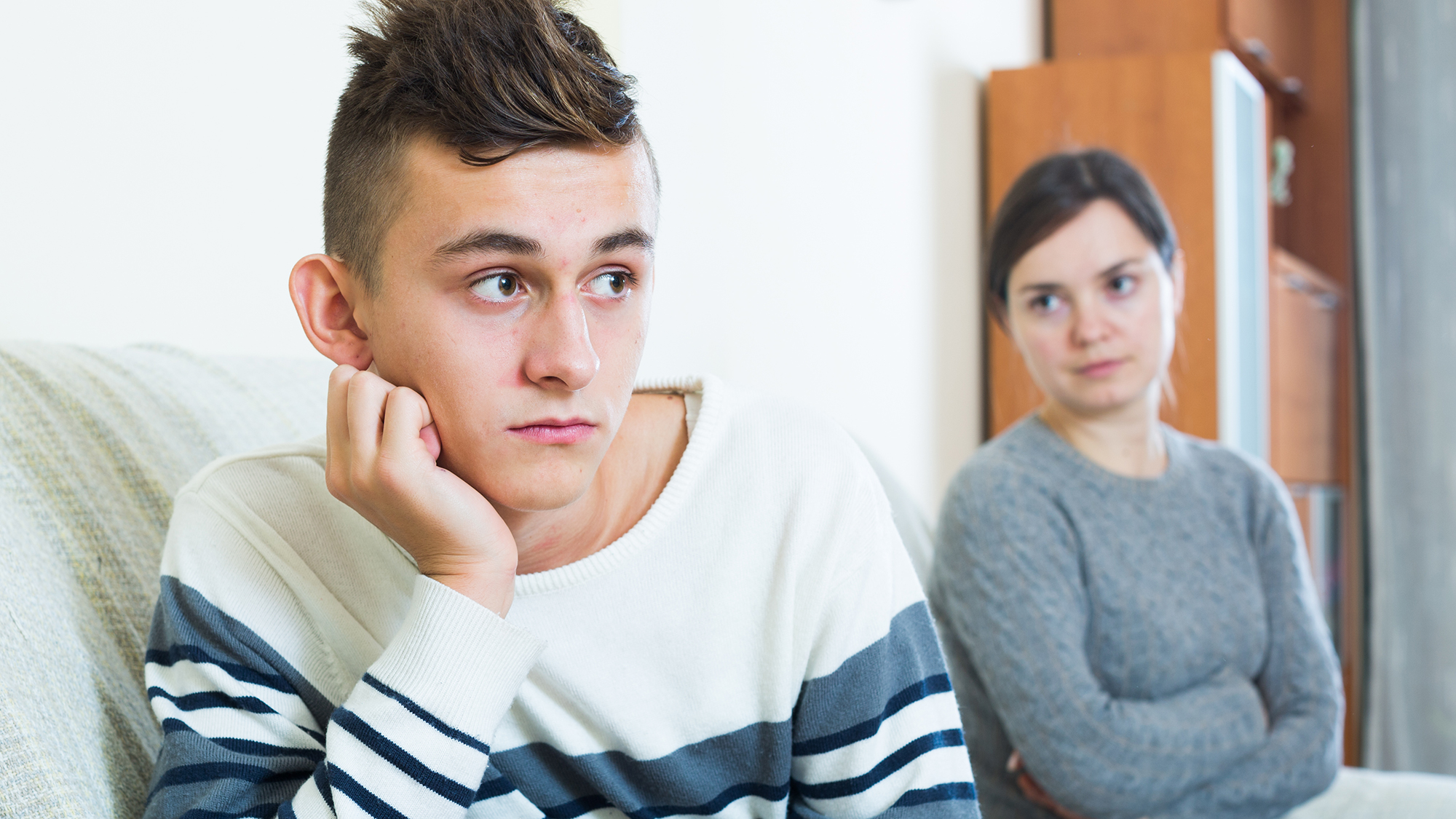 Junge kehrt traurig Mutter den Rücken zu