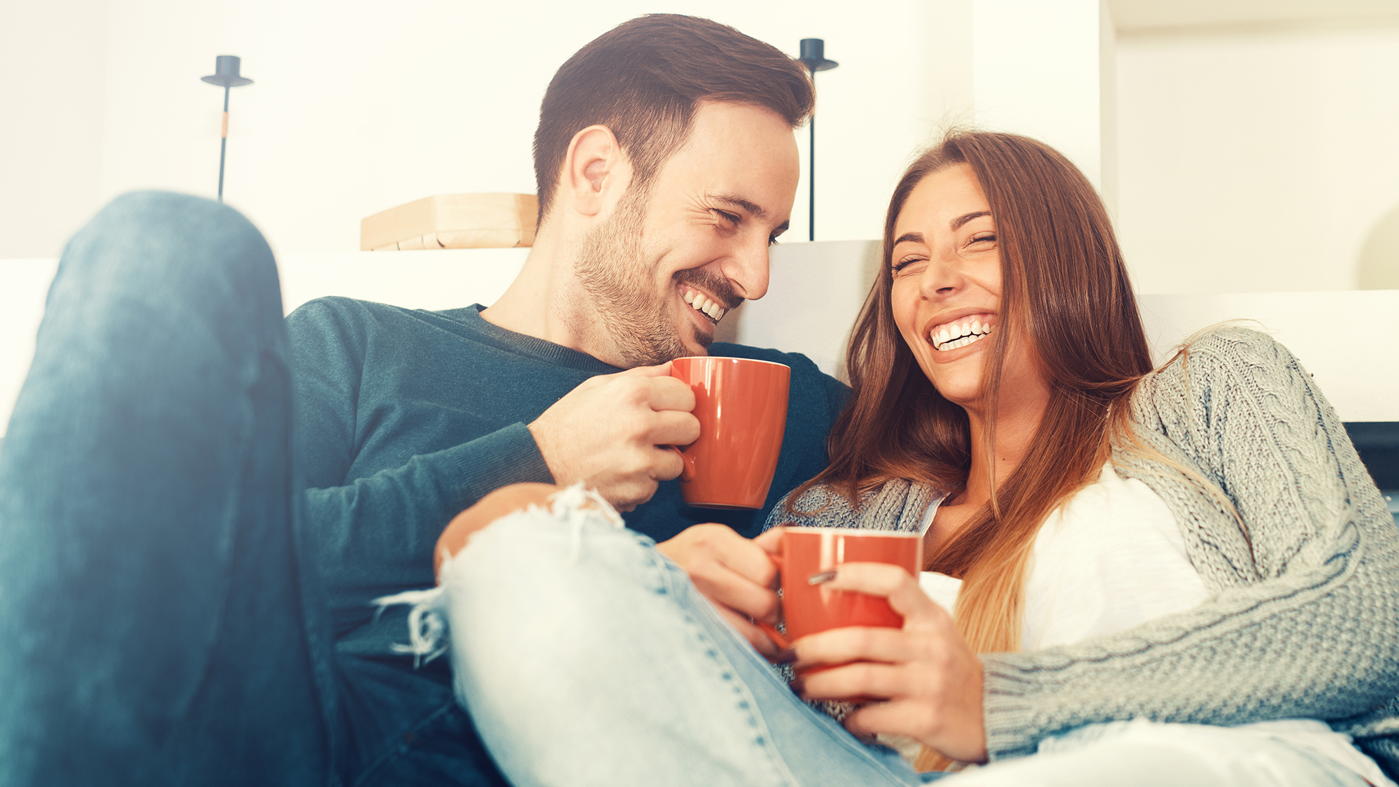 Mann und Frau sitzen lachend auf dem Sofa