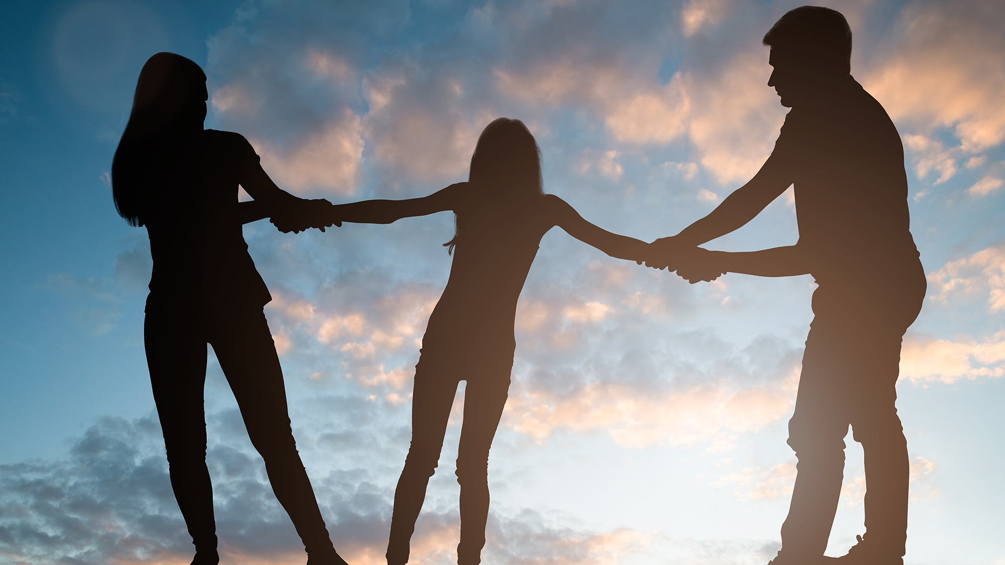 Silhouette Frau links, Kind mit ausgebreitenen Armen in der Mitte, Mann rechts