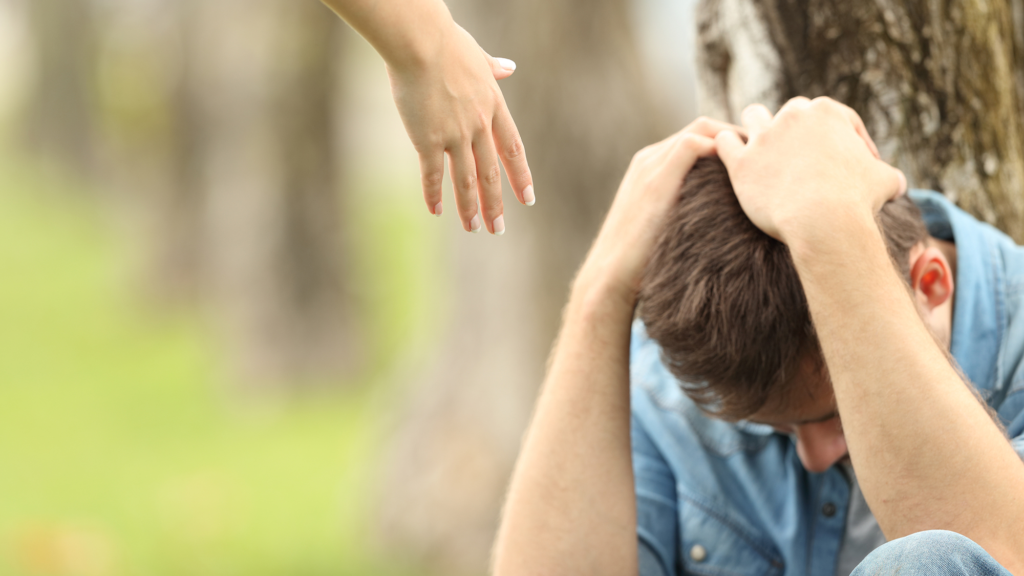 Hand wird traurigen Jungen entgegen gestreckt