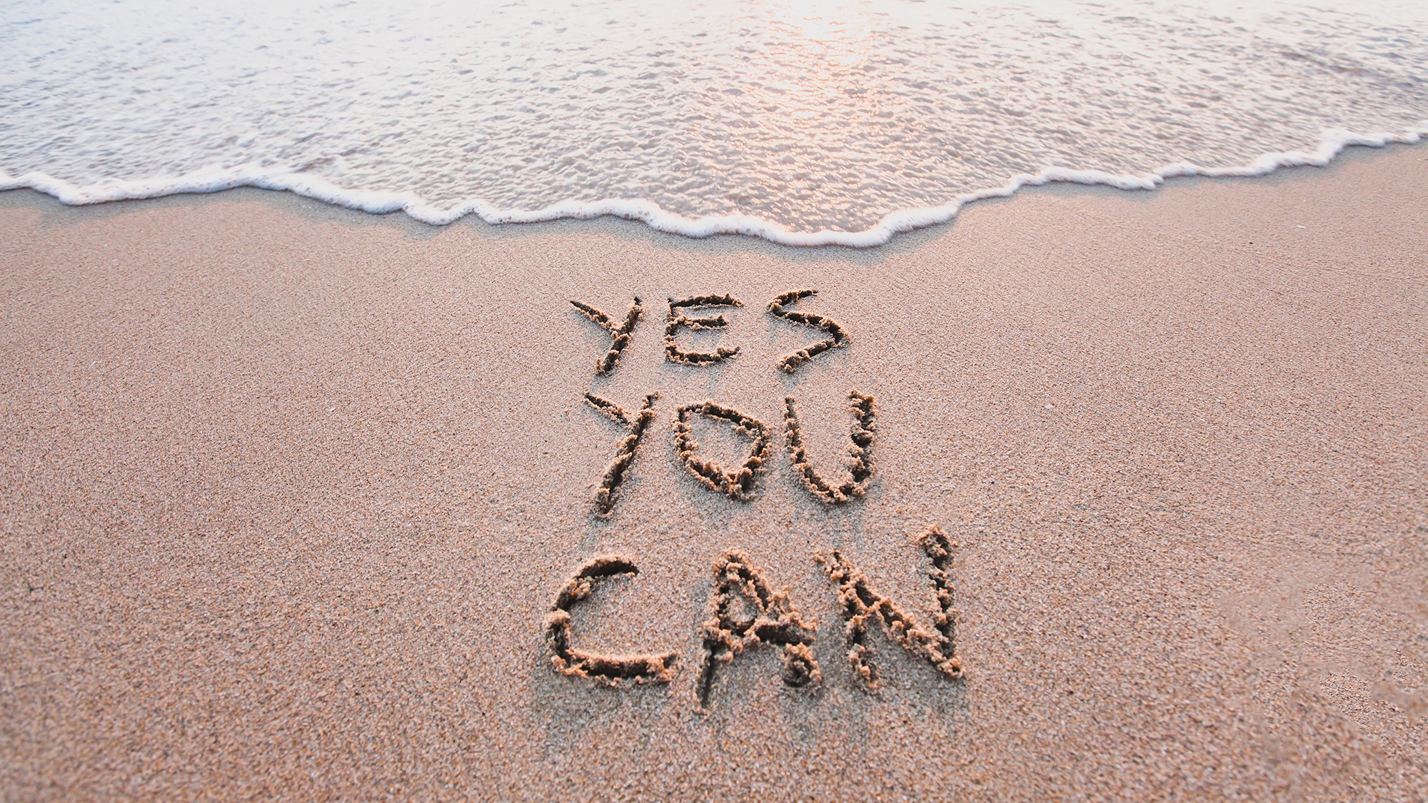 "yes you can" in den Sand geschrieben