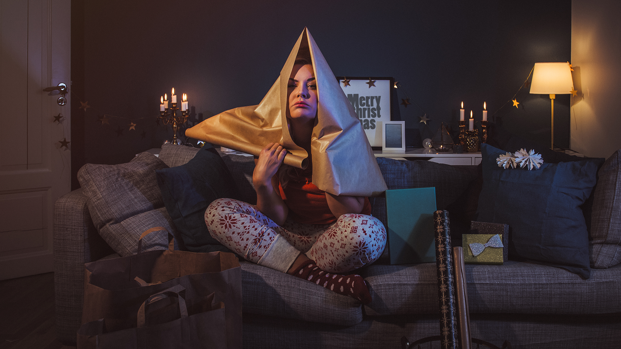 Mädchen sitzt unglücklich auf Sofa zwischen Geschenken