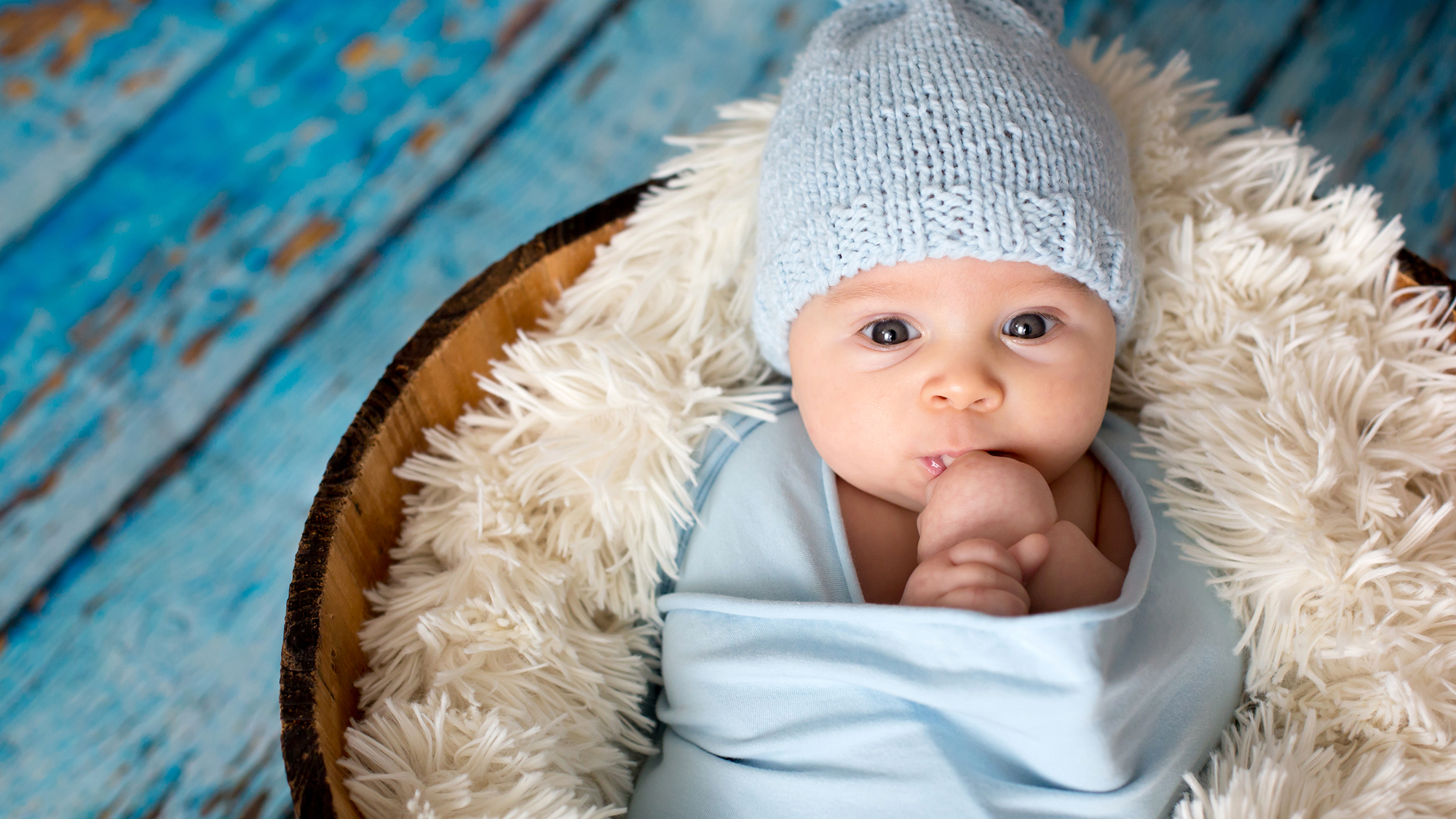 Baby liegt eingewickelt in Fell