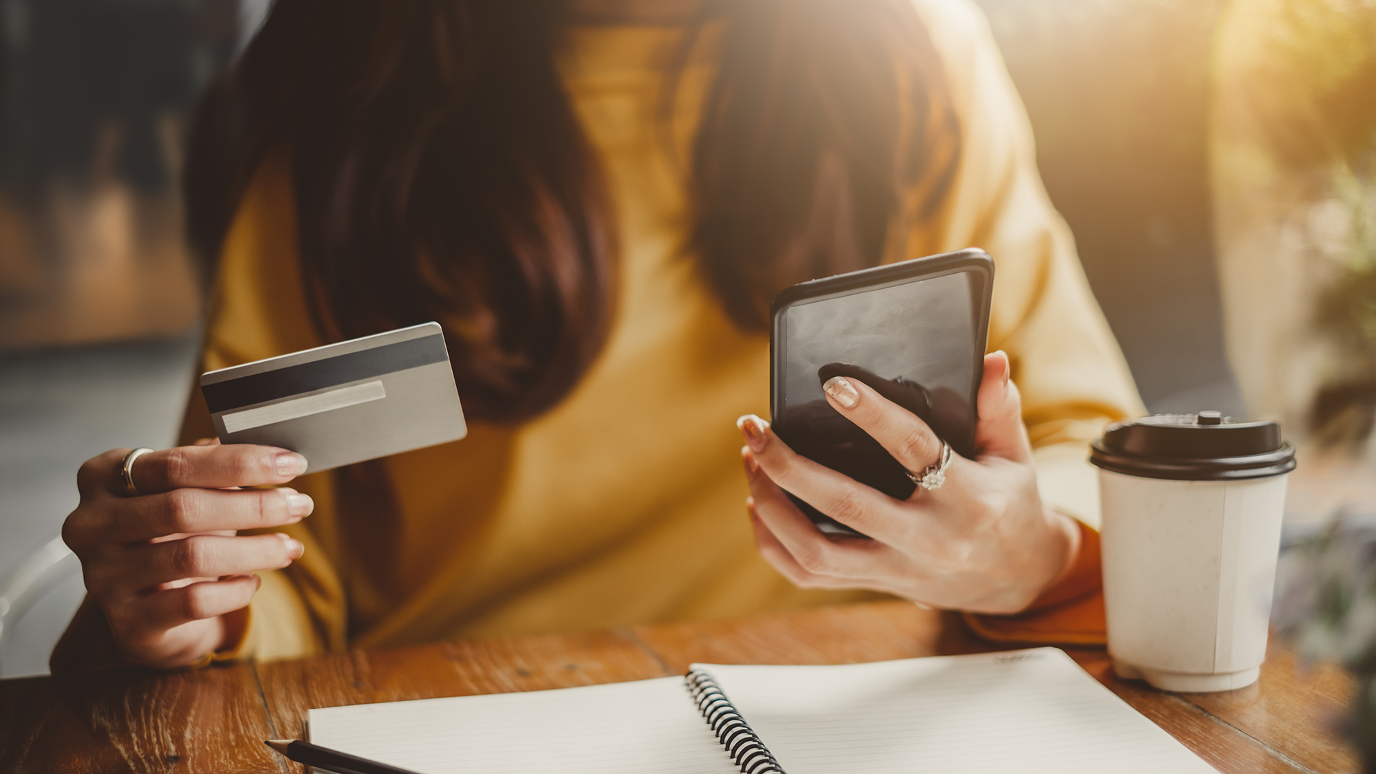 Mädchen hält Handy und Kreditkarte in den Händen