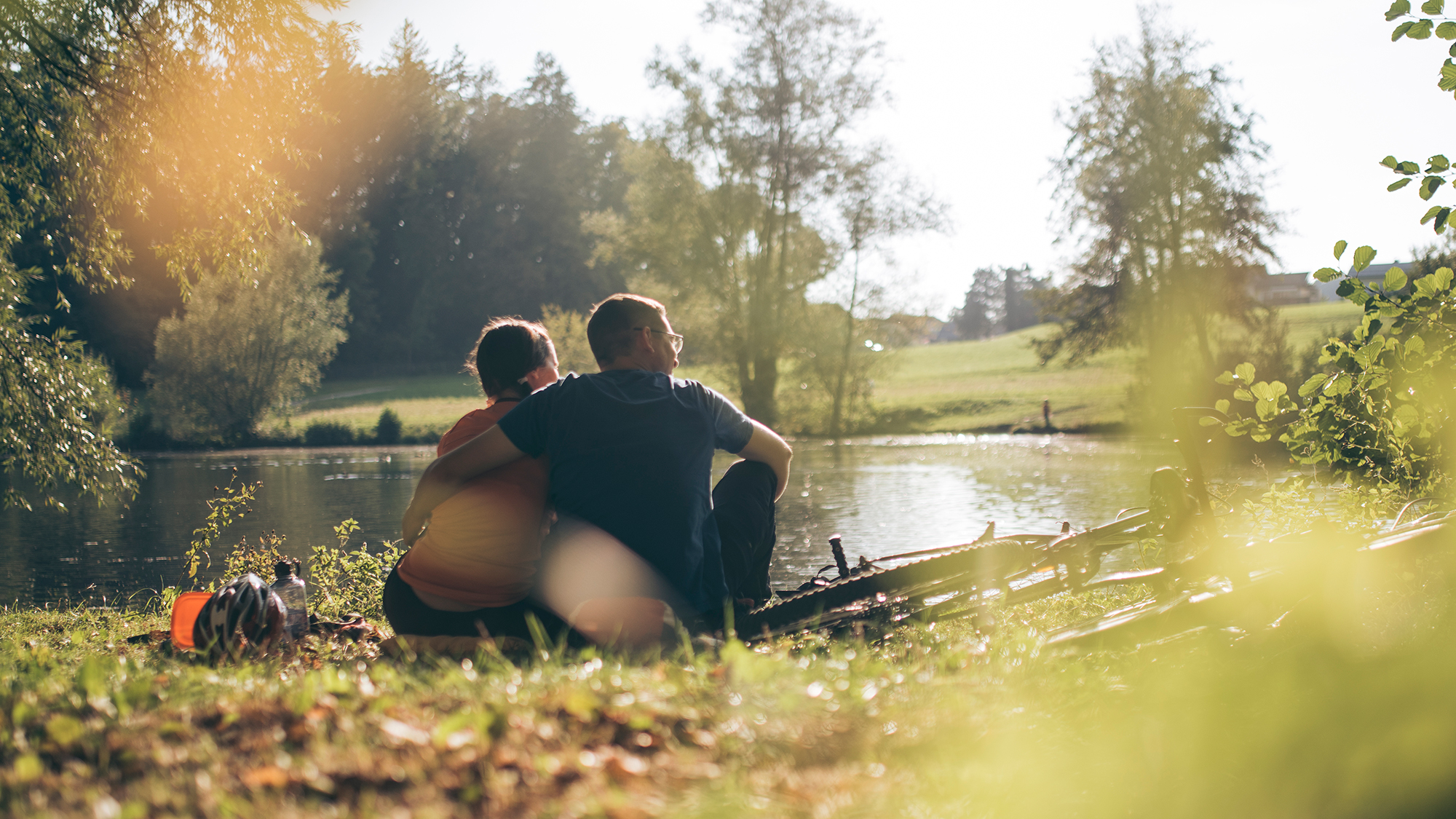 Ein Pärchen sitzt am See und genießt die gemeinsame Zeit