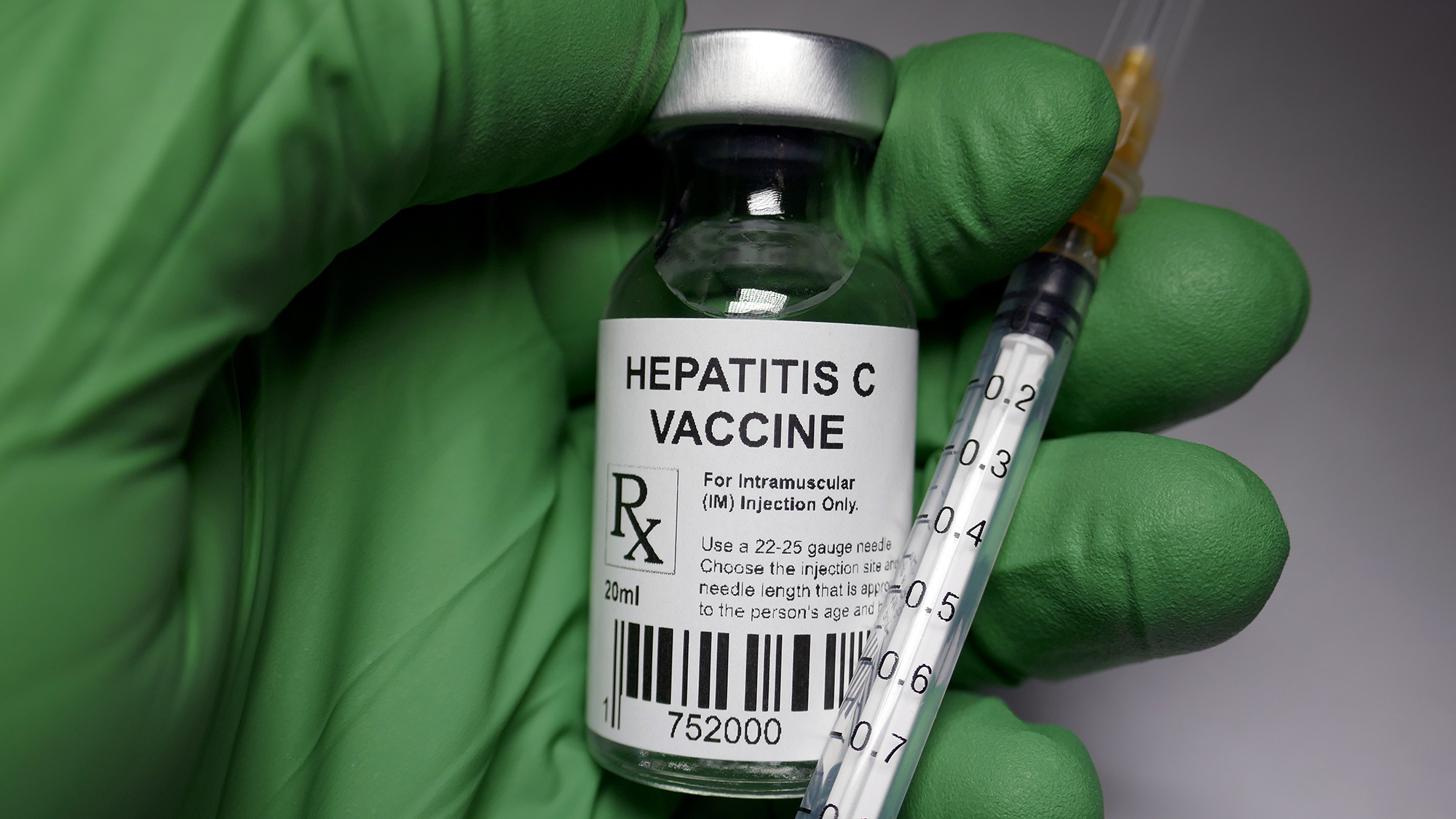 (c) iStockphoto.com/Hailshadow Hand mit grünen Handschuh hält Fläschen mit Aufschrift "Hepatitis C"