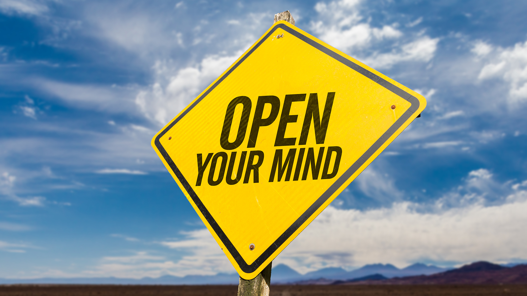 Gelbes Schild mit Aufschrift "open your mind"