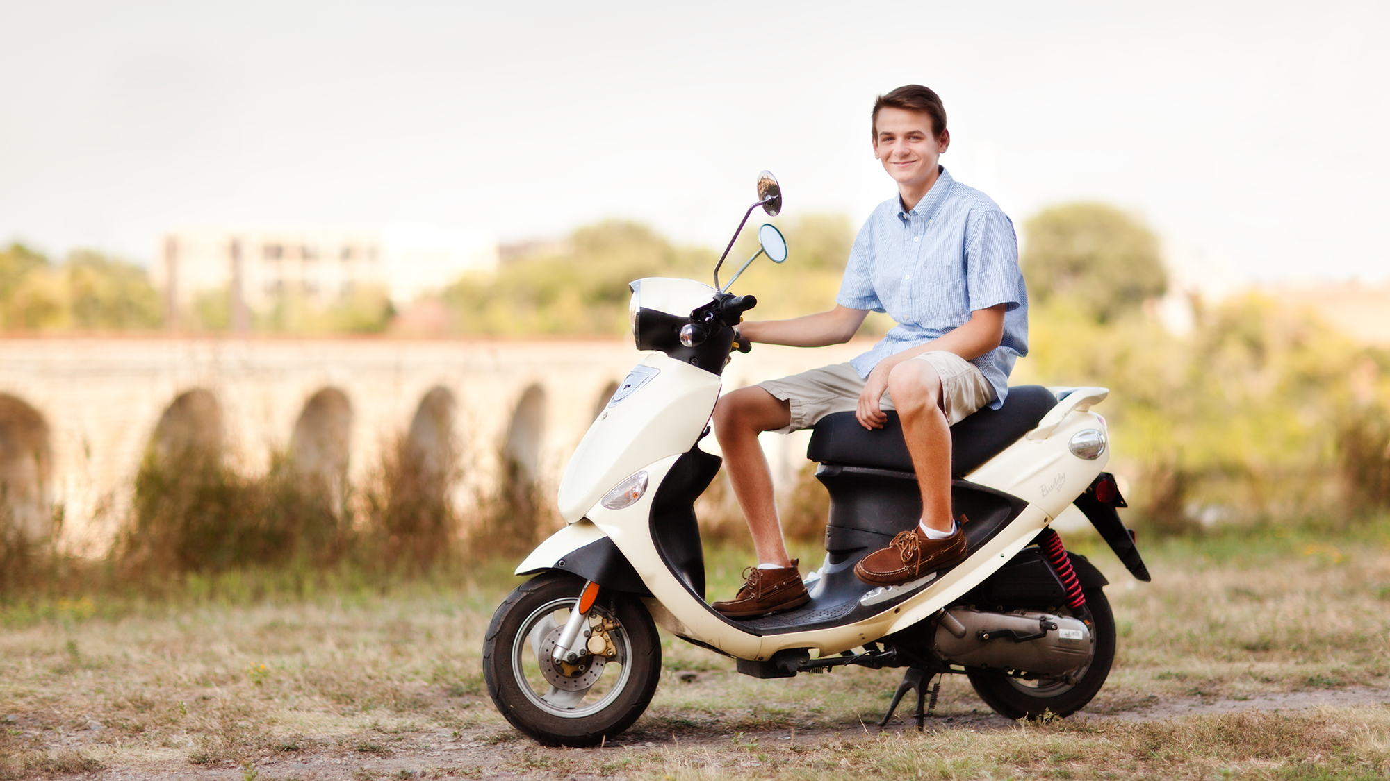 Junge sitzt auf Moped