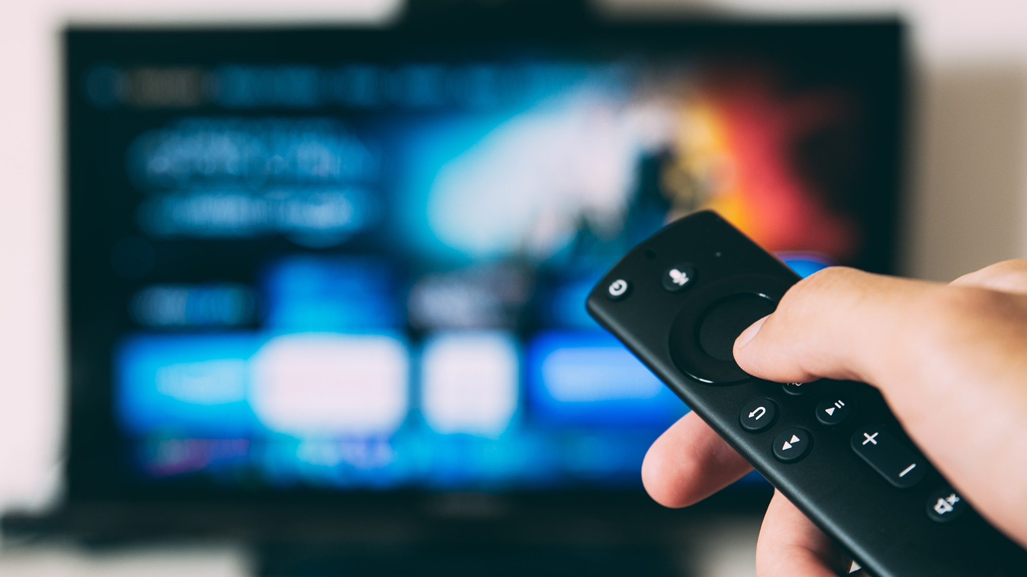 Fernbedienung, im Hintergrund Fernseher