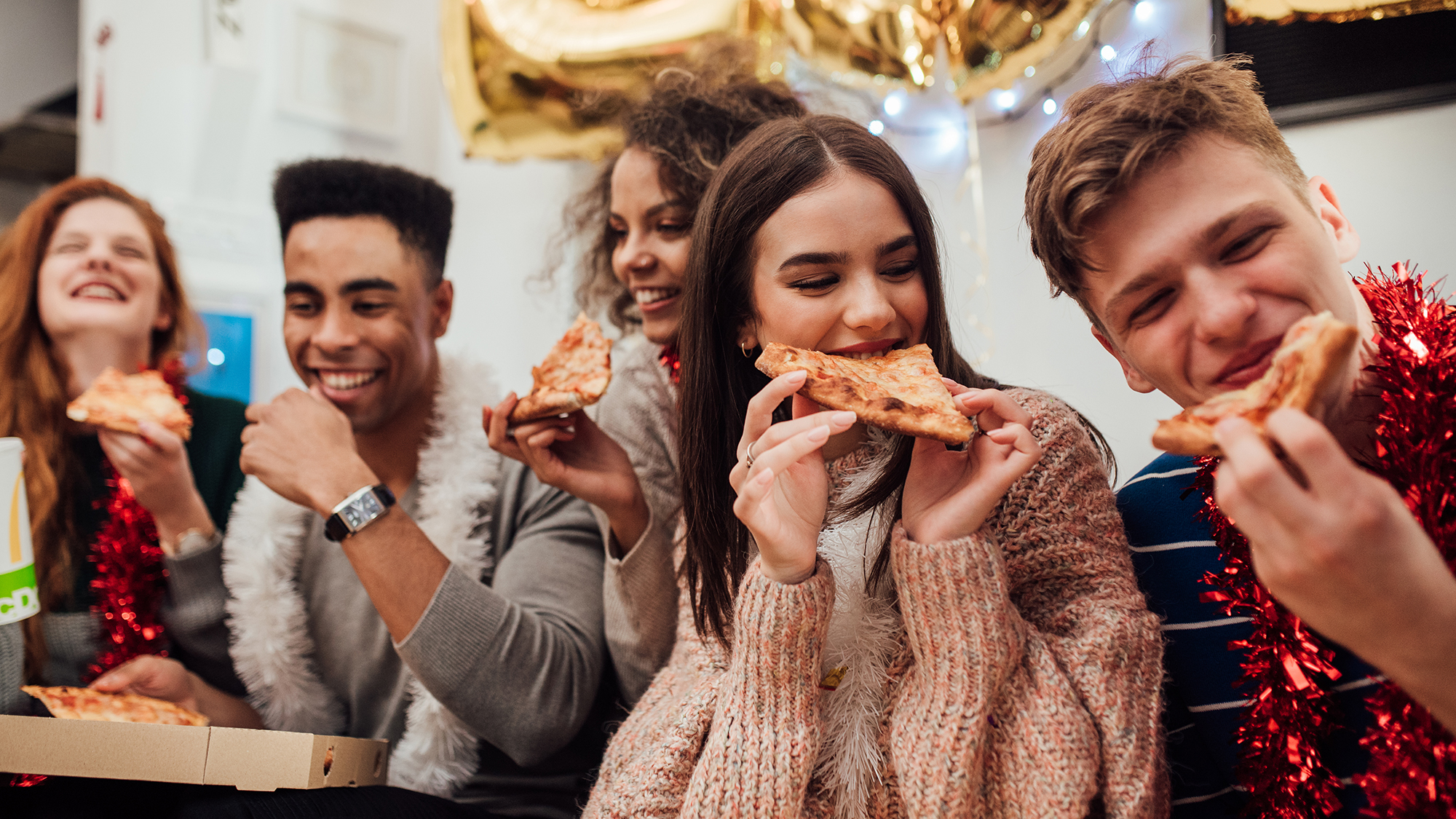 Jugendliche essen Pizza auf Party