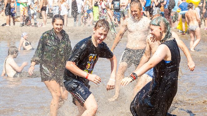 Jugendliche feiern auf Festival im Regen und Schlamm