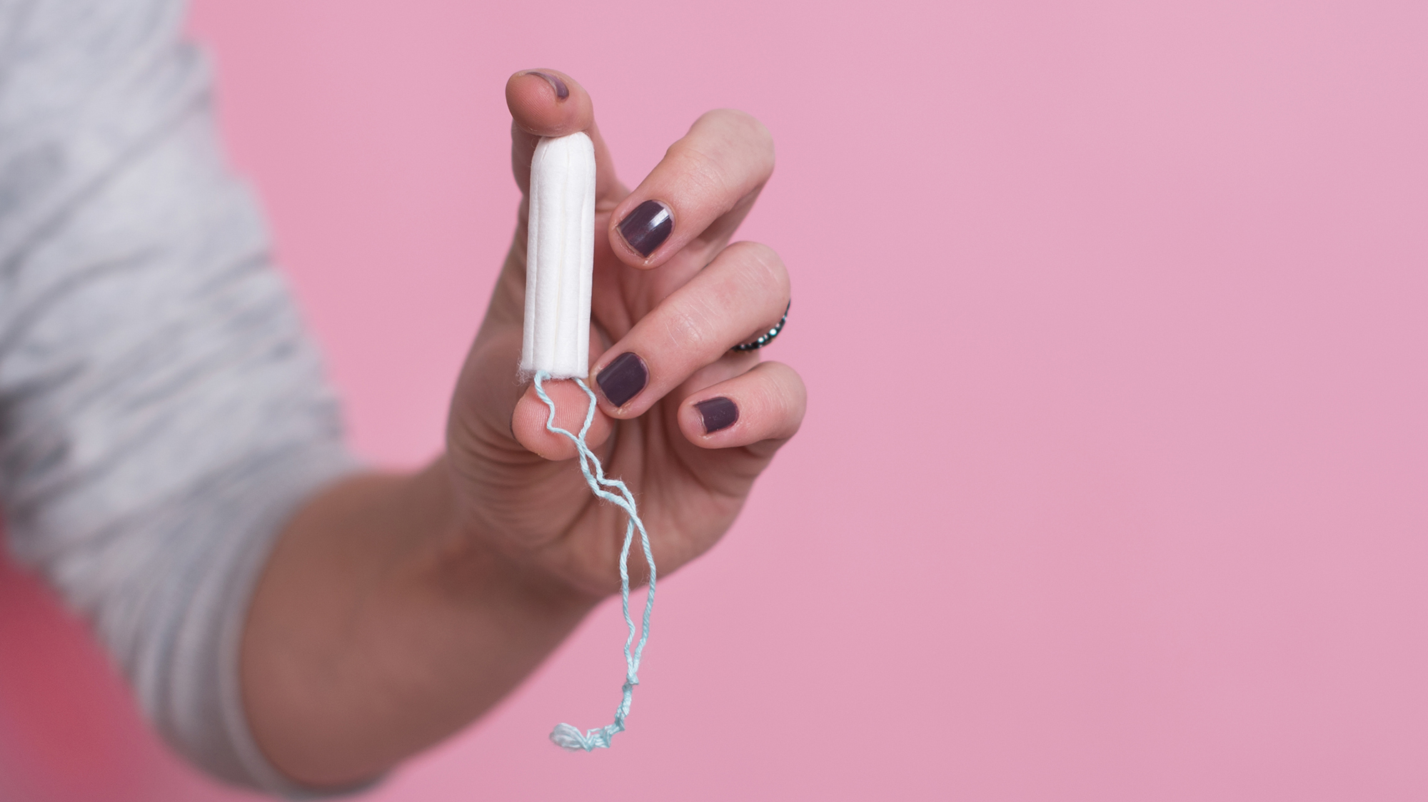 Mädchen hält Tampon zwischen den Fingern