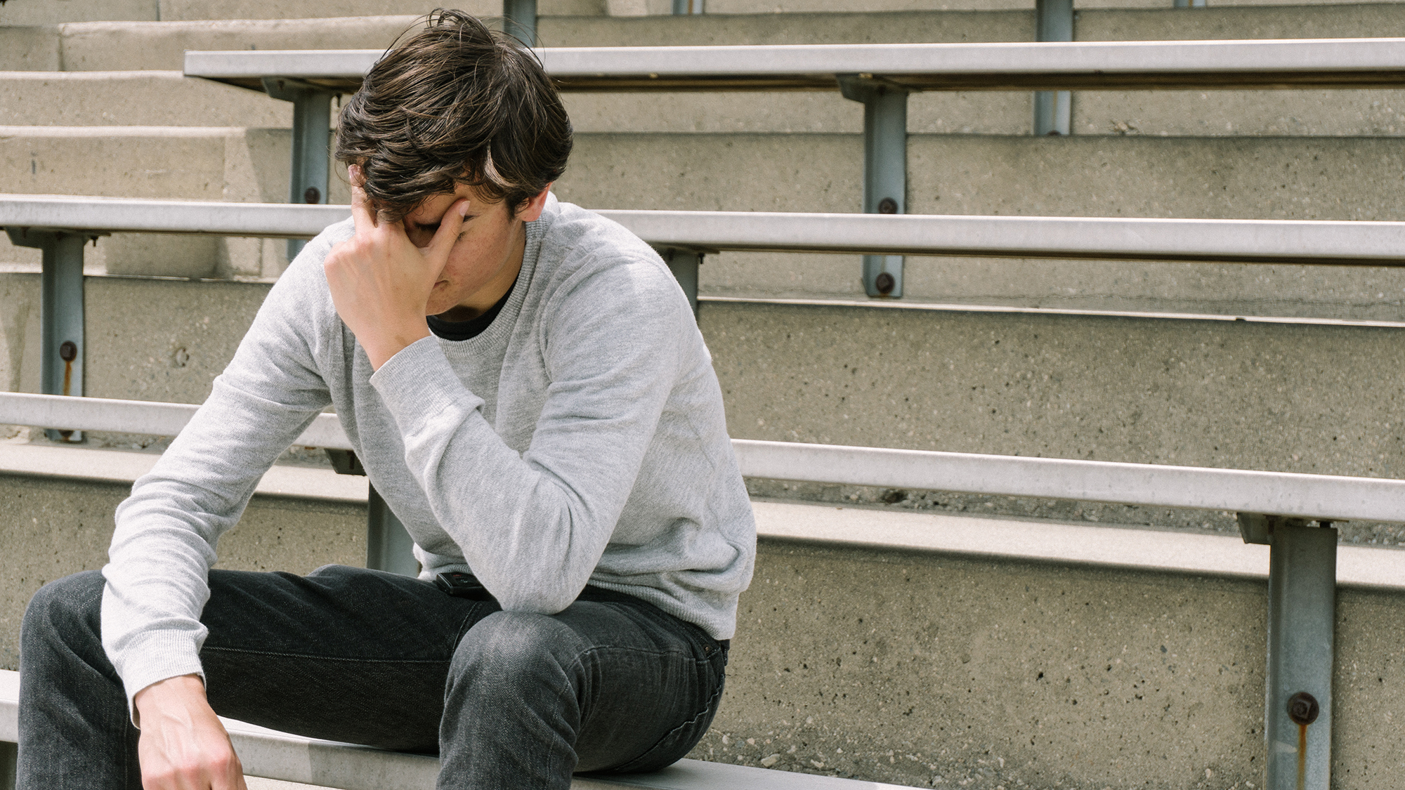 (c) iStockphoto.com/jeremyiswild Junge sitzt verzweifelt auf Bank