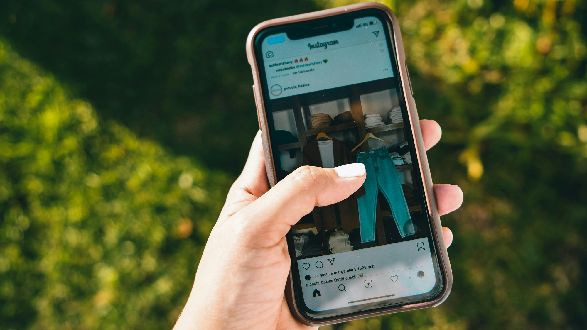 Ein Smartphone wird in der linken Hand gehalten, auf dem ein Bild in der App Instagram zu sehen ist.