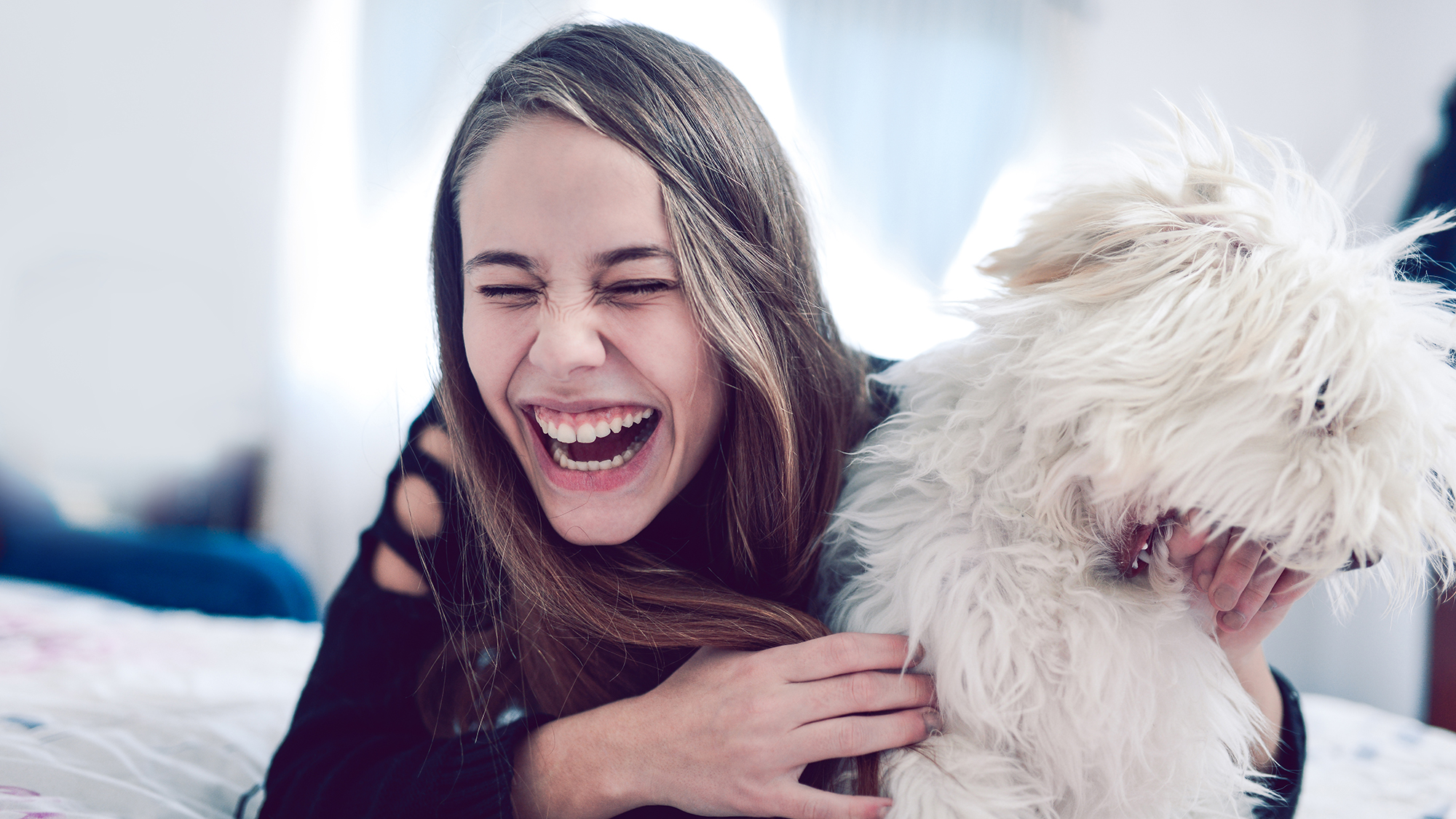 Mädchen kuschelt mit Hund