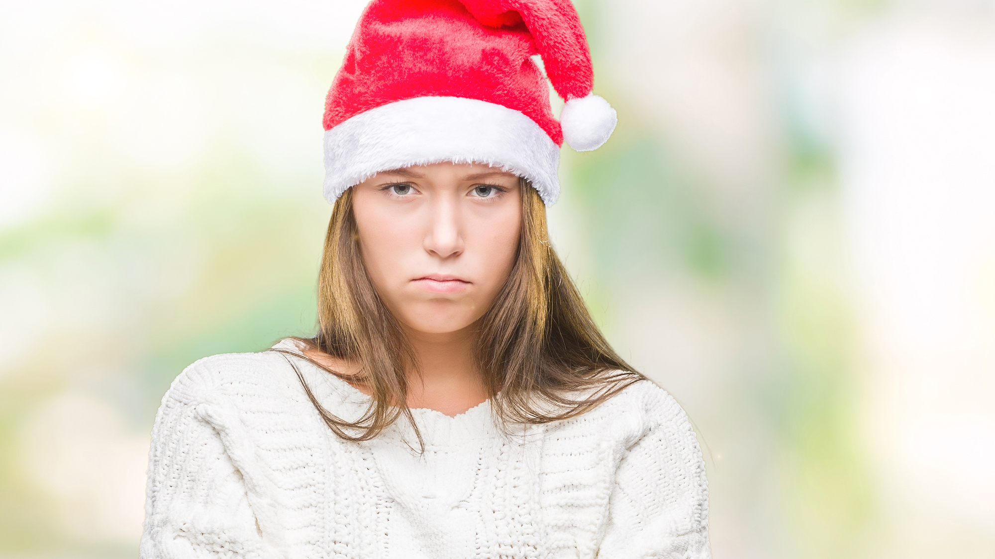 Mädchen mit Weihnachtsmütze schaut unglücklich