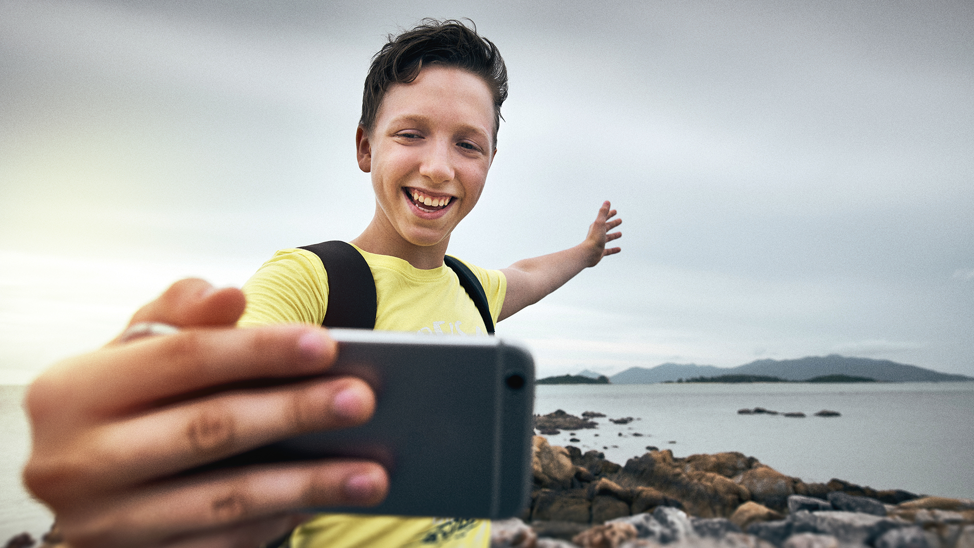 Bub macht Selfie vor einem Strand