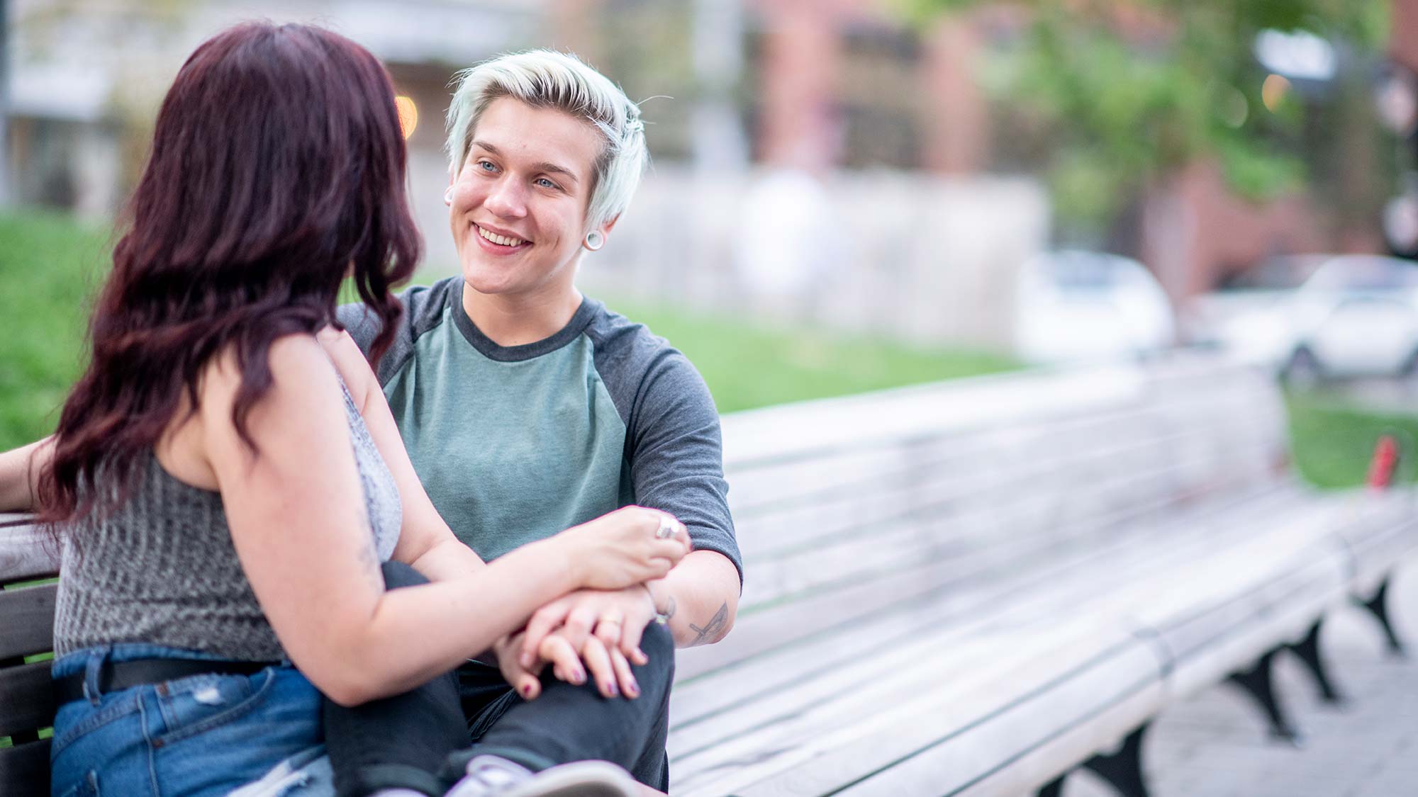 Zwei Jugendliche sitzen verliebt auf Parkbank