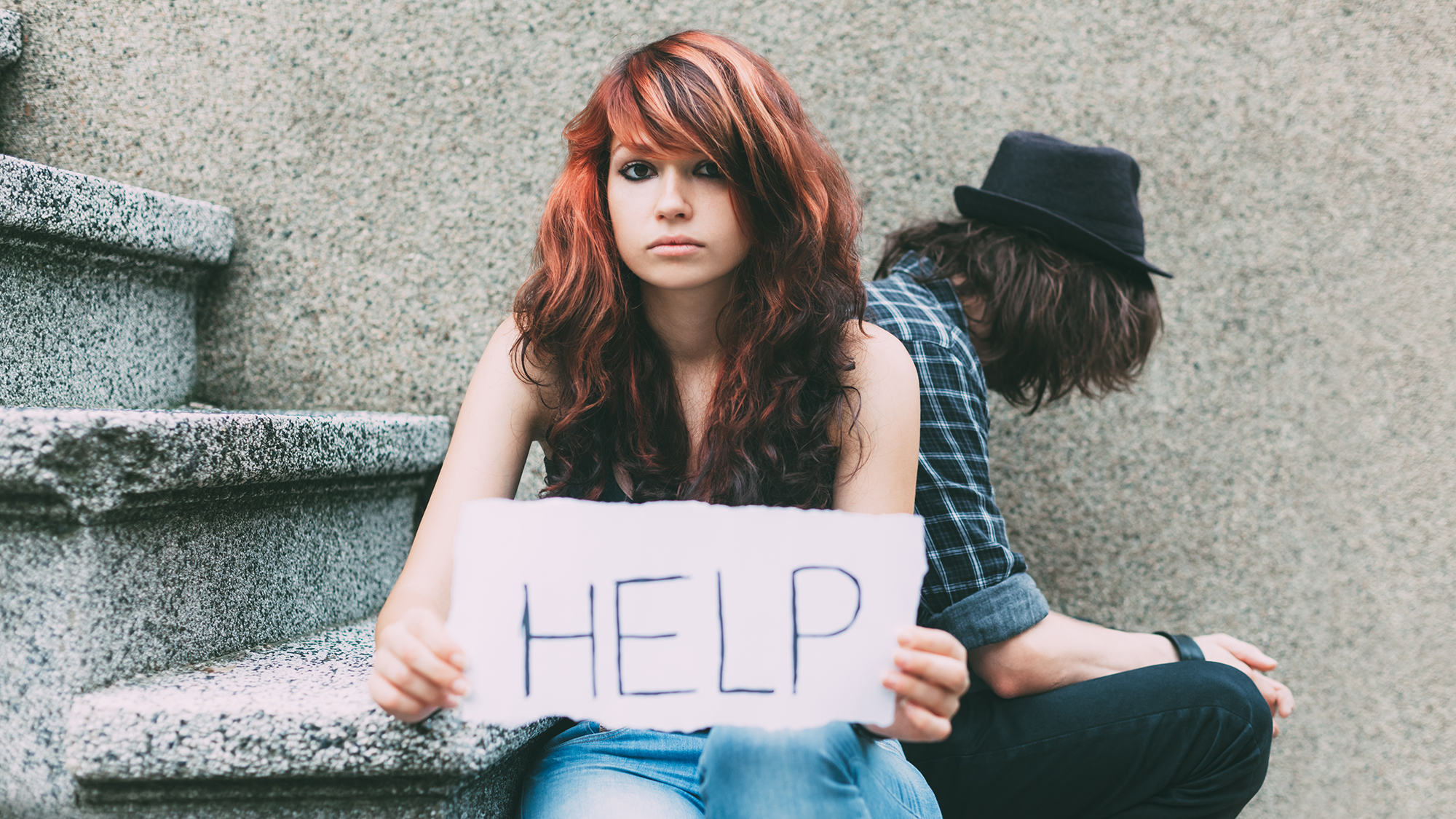 Mädchen hält Schild "HELP" 