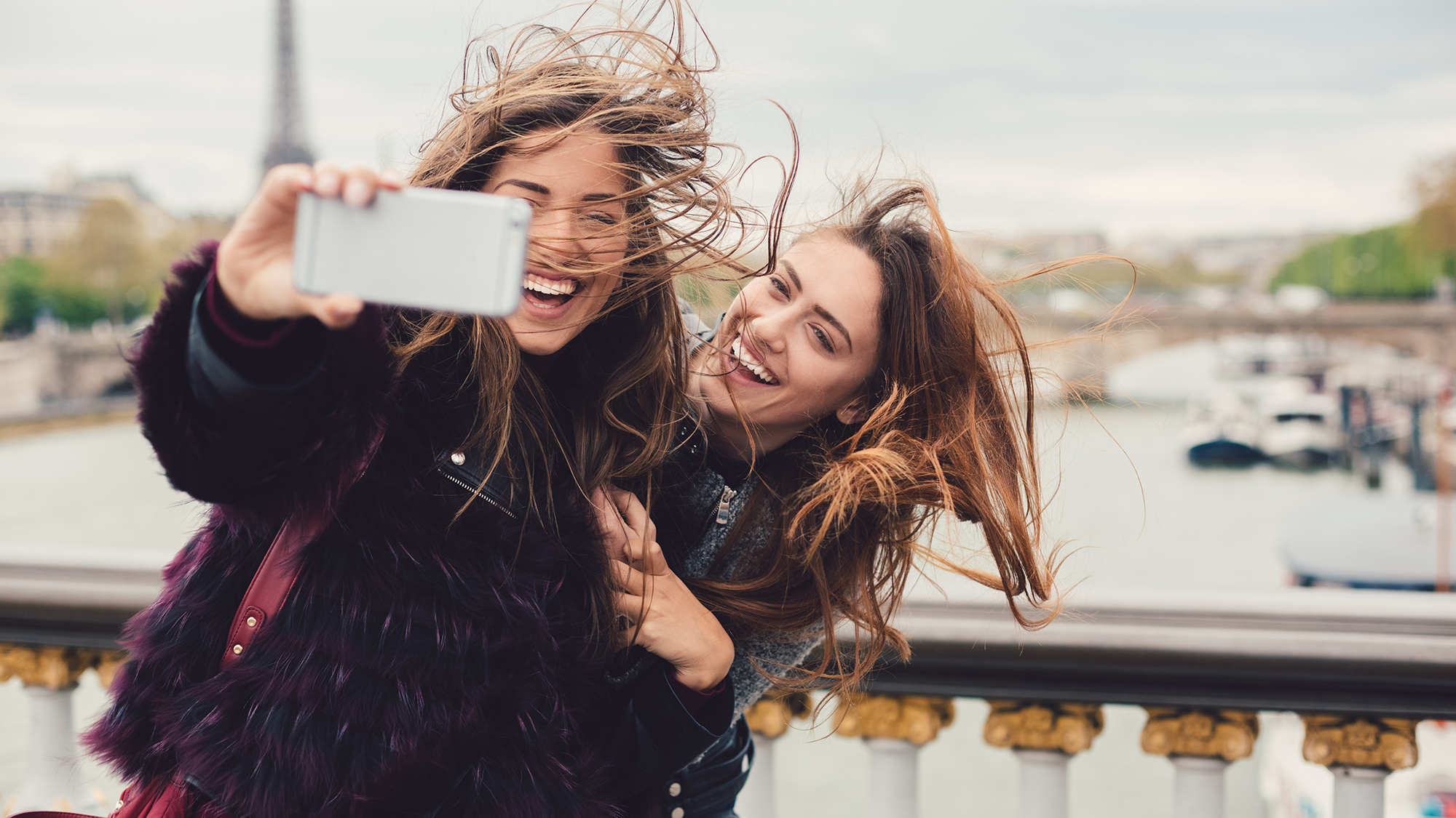 Zwei Mädchen machen Selfie auf Brücke