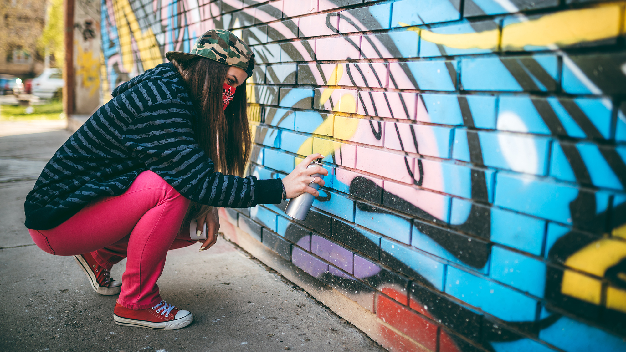 Mädchen sprüht Graffiti