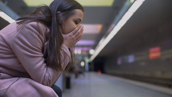 (c) iStockphoto.com/Motortion Mädchen sitzt am Bahnhof und hat ihre Augen wegen Sorgen geschlossen